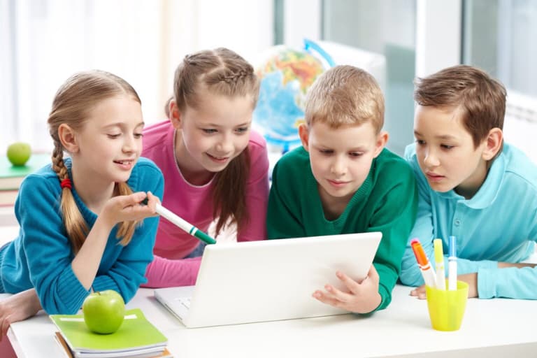 Two boys and two girls learning from a laptop